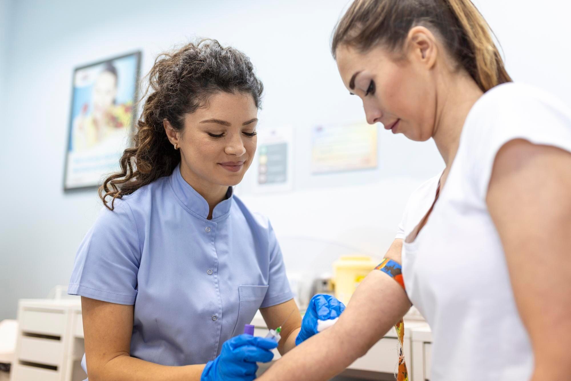 Wemen taking a blood sample from a patient